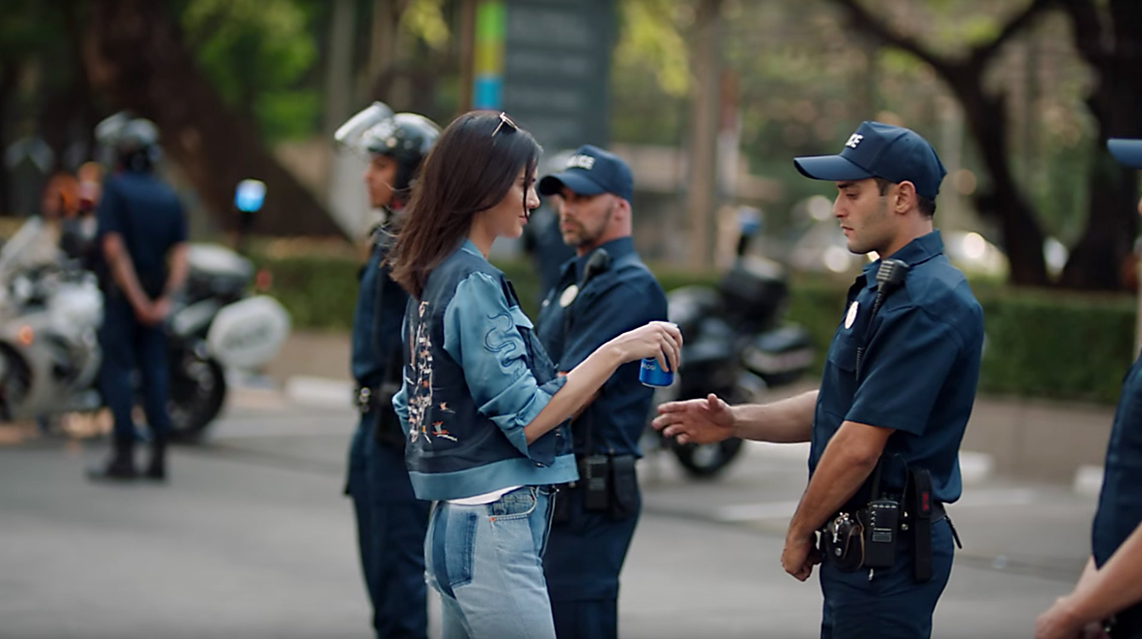 An image from the video wherein Kendall Jenner is giving a can of Pepsi to policemen