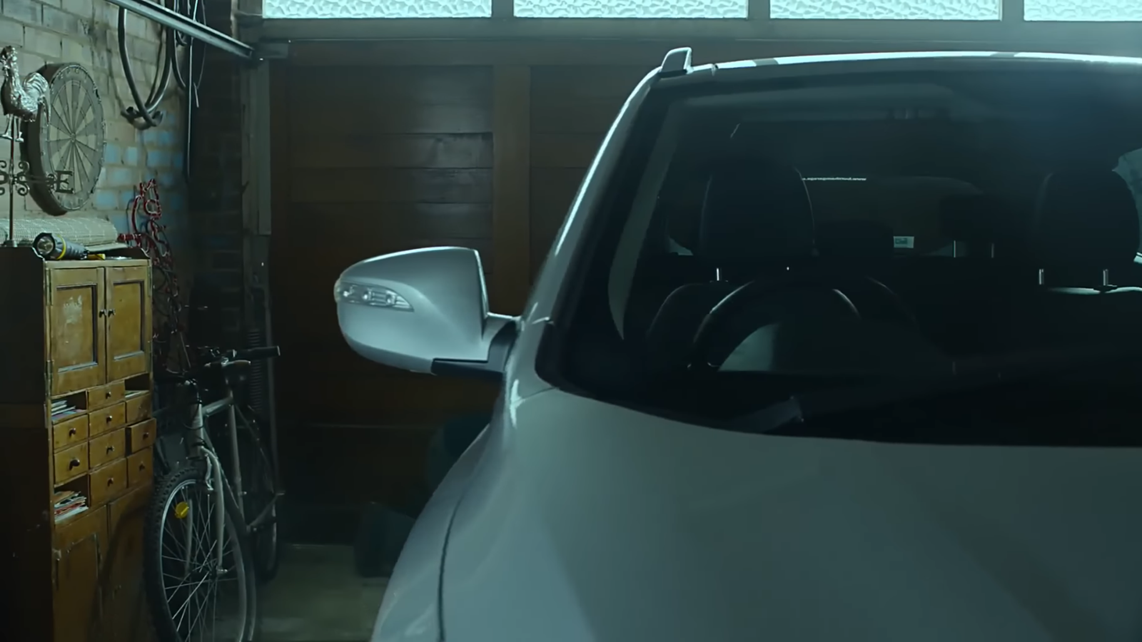An image from the video wherein the setting is being shown: the garage and the car where the man tried to suffocate himself