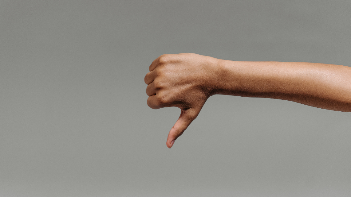 A hand doing a thumbs down sign, signifying dislike or dissatisfaction for something