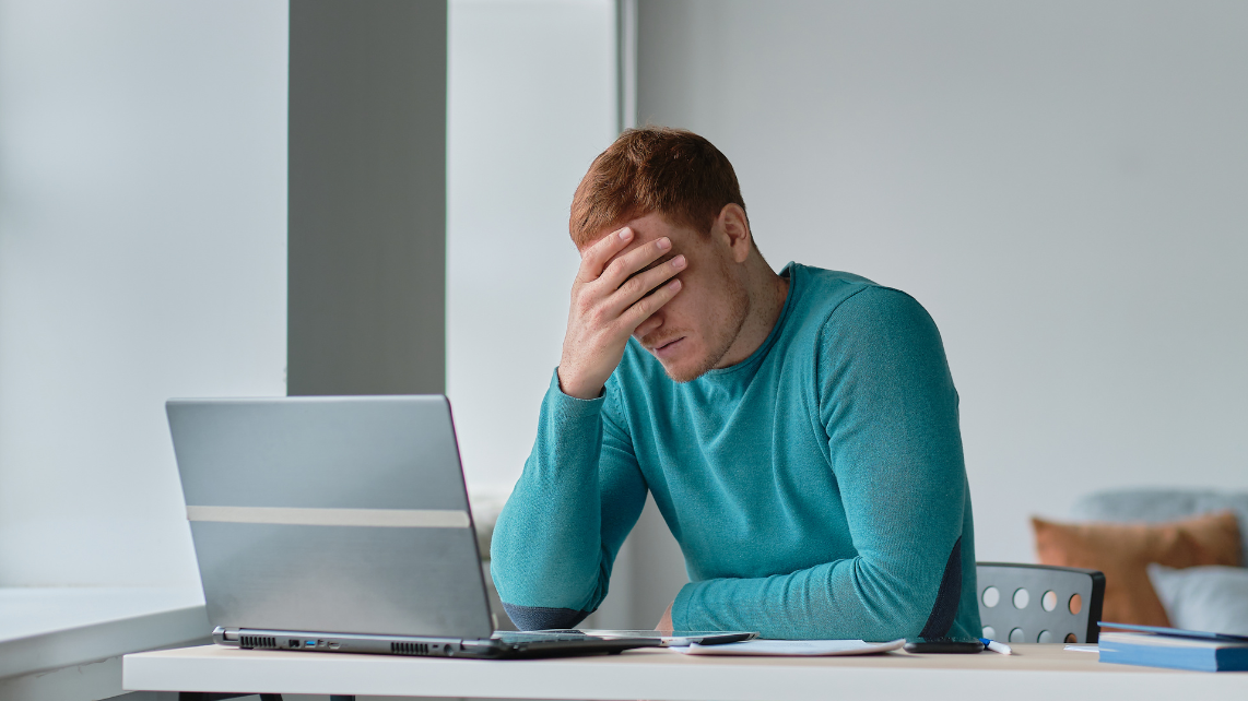 A man using his laptop and feeling distraught